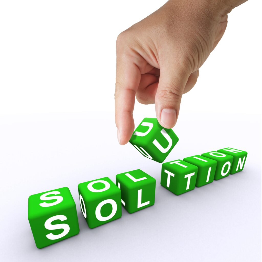 A hand turns over a block with the letter u, making up the word solution.